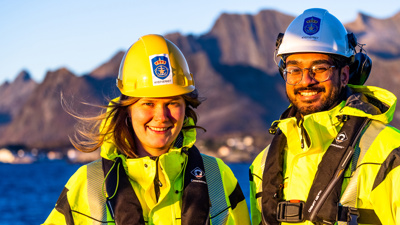 Mann og kvinne rydder søppel på en strand ved Nordkapp.