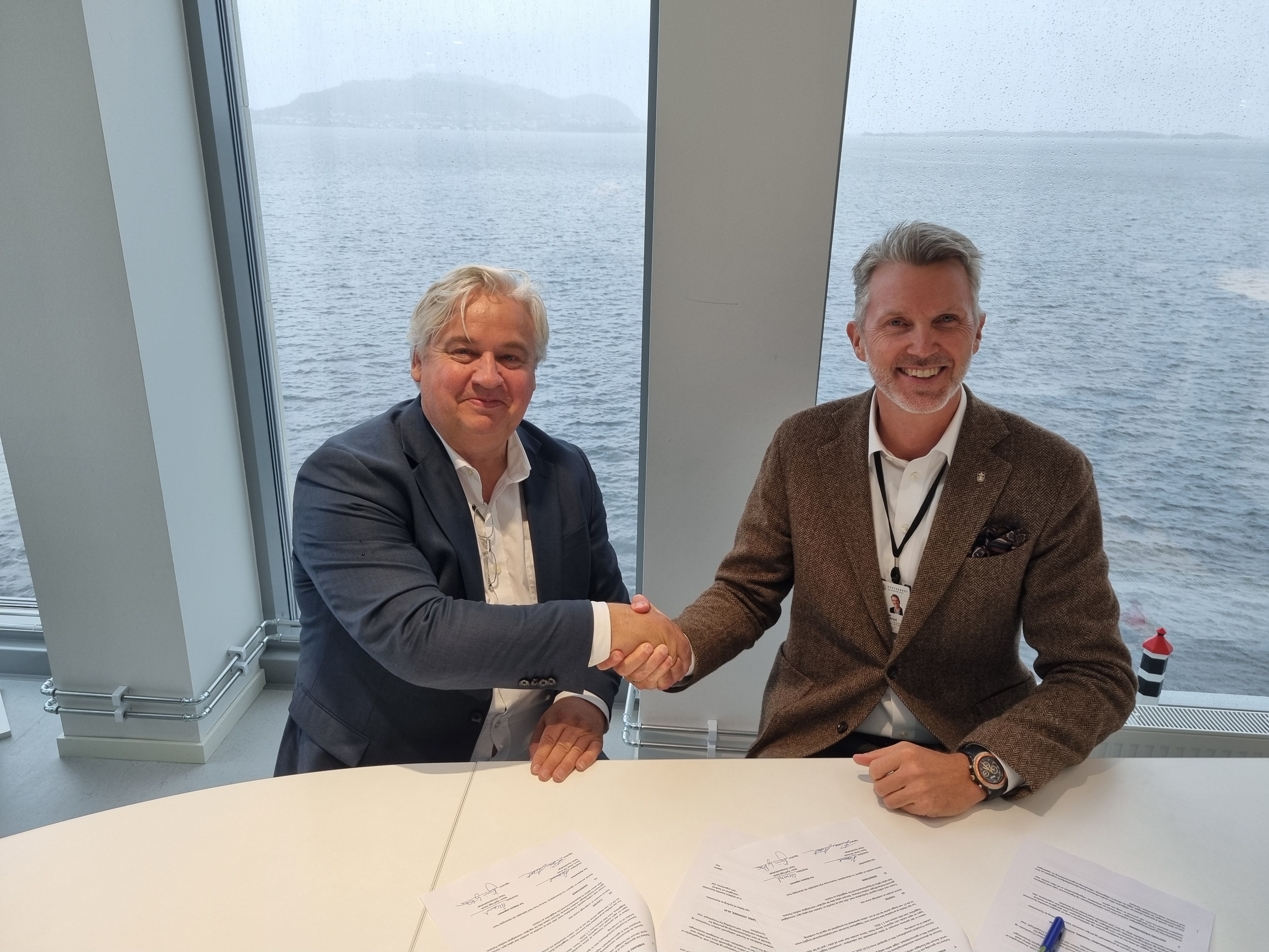 To menn tar hverandre i hånden